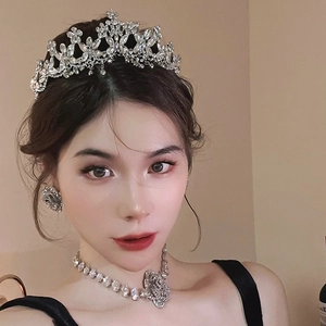 Detailed close-up of a silver rhinestone tiara, necklace, and earrings bridal jewelry set