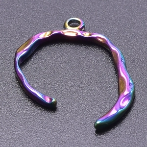 Macro shot of iridescent stainless steel ring pendant with textured colorful metallic finish