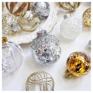 Detailed view of clear Christmas ornaments filled with sequins and golden snowflakes
