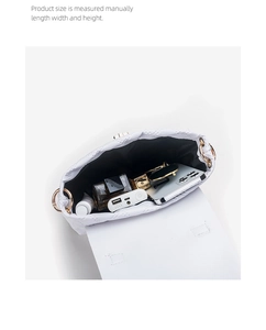 Internal view of white quilted handbag showing spacious capacity and golden metal rings