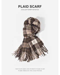 Detail of plaid scarf featuring brown, beige, and green grid pattern with fringe edges
