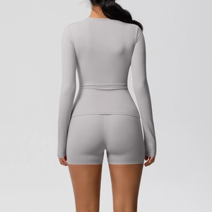 Vue arrière de l'ensemble de yoga gris avec haut à manches longues et short de sport