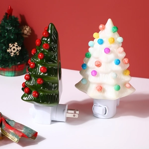 Close-up of ceramic Christmas tree night lights with US plugs on red background