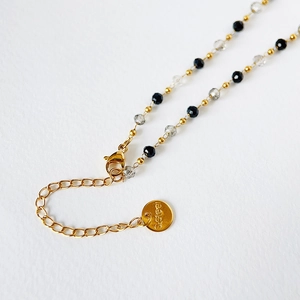 Detail of lobster clasp and gold extender chain on the beaded stainless steel necklace