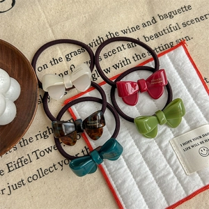Flat lay of colorful acetate bow hair ties in red, white, green and tortoiseshell patterns