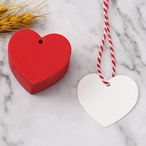 Macro detail of red and white heart gift tags with twine on marble surface