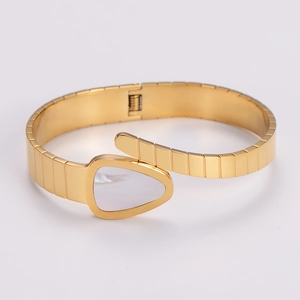 Detailed view of gold snake-shaped stainless steel cuff with white mother of pearl inlay