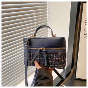 Detail of blue tweed and PU leather patchwork crossbody box bag with gold hardware