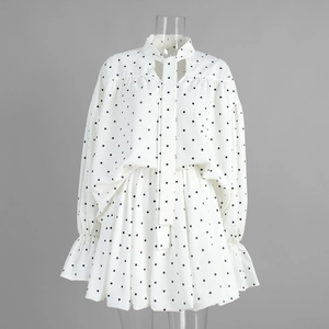 Detail of polka dot blouse showing ruffled cuffs and elegant neck tie bow detail