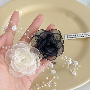 Detail of organza camellia flower necklace with multi-layer white pearls and beads