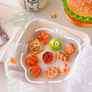 Detailed view of miniature food resin brooches like burgers and donuts in a box