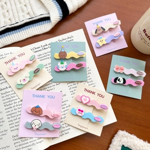 Close-up of colorful cartoon hair clips in macaque colors on decorative paper cards