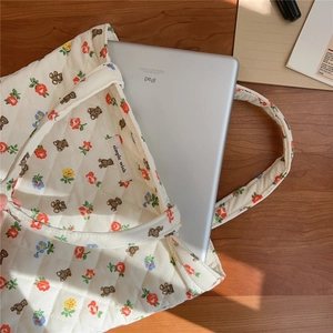 Macro detail of quilted cotton tote bag with bear patterns showing 11-inch tablet capacity