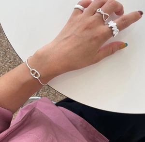 Close-up of 925 sterling silver braided ring and bracelet set on a model hand