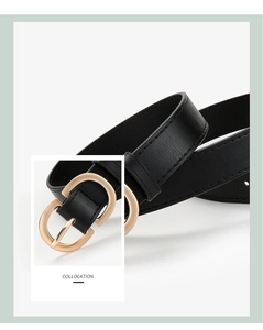 Detail of minimalist black leather belt with a polished gold-tone metal buckle