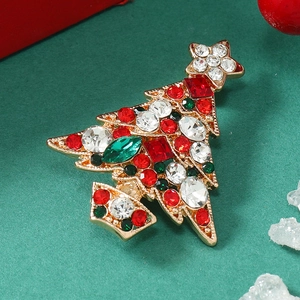 Detail of Christmas tree brooch with colorful rhinestones on a festive green background