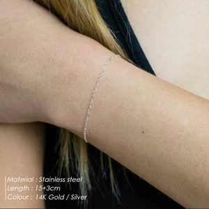 Detail showing a minimalist 14K gold plated stainless steel bracelet worn on a wrist