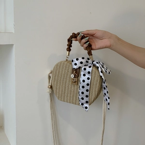 Fashionable straw crossbody bag with brown handle and silk scarf detail
