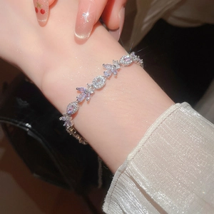 Macro shot of silver leaf bracelet with purple and clear cubic zirconia on wrist