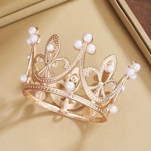 Detailed macro view of golden alloy tiara with intricate filigree and white pearls