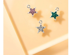 Macro shot of colorful star-shaped alloy pendants with pink, green, and clear crystals