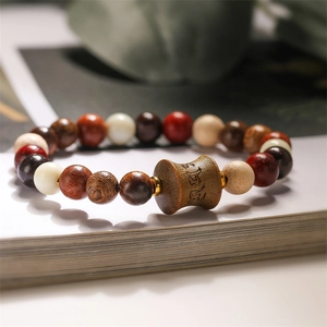 Macro shot of ethnic beaded bracelet with engraved wooden barrel bead and natural stones
