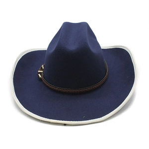 Détail d'un chapeau de cow-boy en feutre bleu marine avec bord blanc et bande tressée
