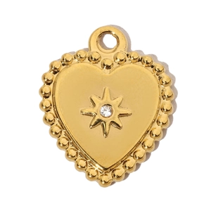 Macro detail of gold heart pendant featuring a starburst engraving and central crystal