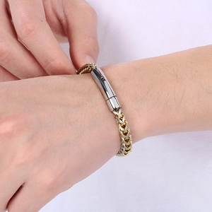 Close-up of two-tone wheat chain bracelet with secure mechanical clasp on wrist
