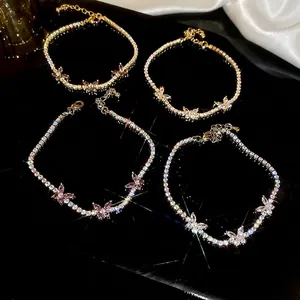 Bracciali di fiori in zircone scintillante in vari colori su uno sfondo nero riflettente