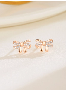 Macro view of rose gold bow earrings with shimmering cubic zirconia inlay details