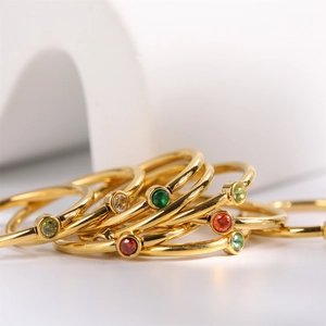 Macro shot of minimalist gold rings with vibrant multicolored December birthstone gems