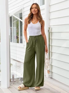 Close-up of olive green wide-leg pants showing premium fabric texture and drawstring waist