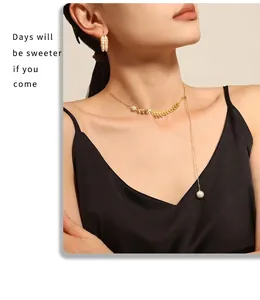 Detailed view of the 18k gold wheat leaf necklace and pearl tassel set on the model