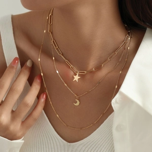 Three-layer gold necklace set featuring star and moon pendants on a minimalist metal chain