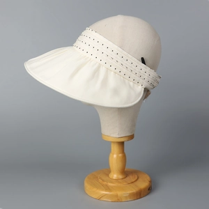 Detail of beige organza sun visor with stylish polka dot ribbon and pleated wide brim