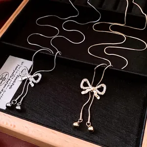 Bow pendant necklace in gold and silver finish with zircon stones on sleek snake chain
