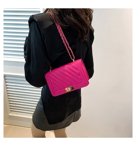 Detailed back view of a fuchsia quilted crossbody bag with a golden chain strap