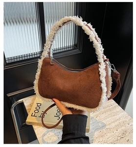 Detail of brown corduroy shoulder bag featuring soft white faux fur trim and sleek zipper