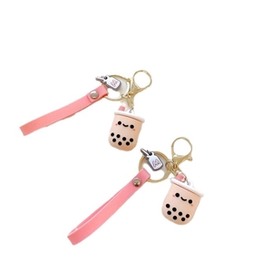 Cute milk tea cup keychain with pink wrist strap and golden metal ring on white background