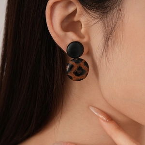 Detailed macro shot of vintage leopard print heart geometric earrings on a model