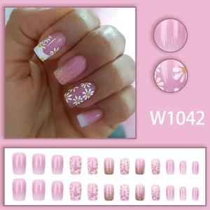 Press-on nail set featuring pink gradient design with white daisy floral patterns and glitters