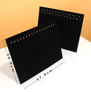Detail of black velvet jewelry display board with metal hooks for necklaces and bracelets