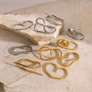 Minimalist gold and silver stainless steel rings in organic irregular shapes on rock base