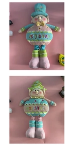 Detail of cute telescopic Christmas plush elves in blue and green hats with embroidery