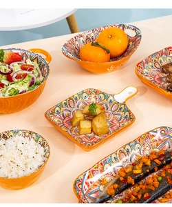 Detailed set of Bohemian ceramic tableware featuring vibrant patterns and orange exterior