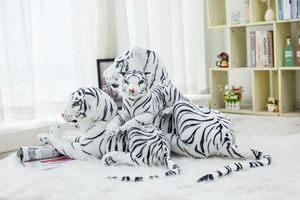 Detailed view of three white tiger plush toys in various sizes on a soft white carpet