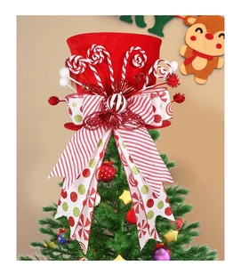 Detail of red velvet Christmas tree topper hat with striped bow and candy cane decor