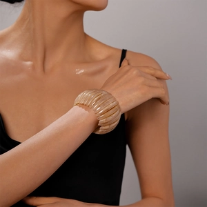 Détail d'un gros bracelet en acrylique avec texture écaille beige sur le poignet