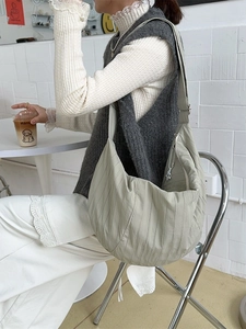 Sage green minimalist dumpling bag with pleated texture and adjustable shoulder strap